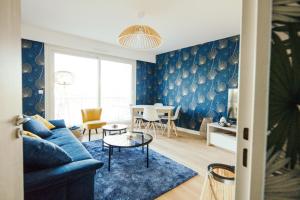 uma sala de estar com um sofá azul e uma mesa em The Rhuys - Cosy-balcony with superb Loire view - all on foot - Parking em Nantes