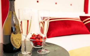 twee champagneglazen op een tafel naast een fles champagne bij HeMi Suites in Milaan