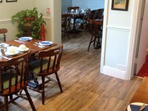 a dining room with a wooden table and chairs at The Beeches in Clacton-on-Sea