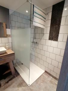 La salle de bains est pourvue d'une douche avec une porte en verre. dans l'établissement GITE COCOONING LE HAMEL, à Le Hamel