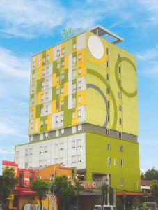 un edificio amarillo con un gran cartel en Zest Jemursari by Swiss-Belhotel International en Surabaya