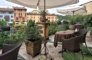 a patio with a table and chairs and an umbrella at Hotel Piroscafo in Desenzano del Garda