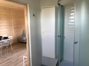 a glass shower in a room with a table at DomkiToTu in Jarosławiec +30 photos