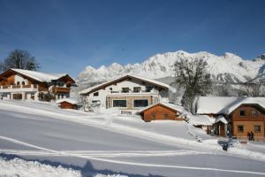 un pueblo cubierto de nieve con montañas en el fondo en Haus Bergliebe, en Schladming