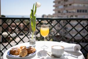 a table with a glass of orange juice and a plate of food at Ele Andarax in Aguadulce