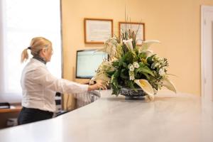 une femme debout au comptoir avec un vase de fleurs dans l'établissement Ele Andarax, à Aguadulce
