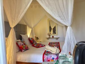 a bedroom with a canopy bed with pillows at Hotel Djerba Orient in Mezraya