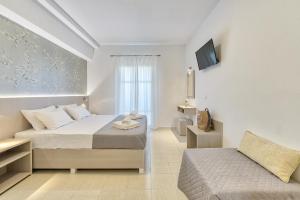 a white bedroom with a bed and a couch at Artemis Hill Studios in Argasi