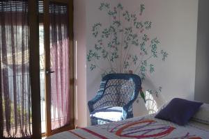 a bedroom with a bed and a chair next to a window at El molino del abuelo in Montecorto