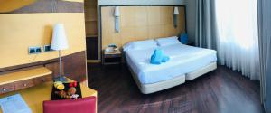 a bedroom with a bed and a desk with a chair at Best Western Hotel Mediterraneo in Castelldefels