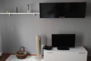 een woonkamer met een tv en een witte kast bij Apartamento Soleado in Tarifa