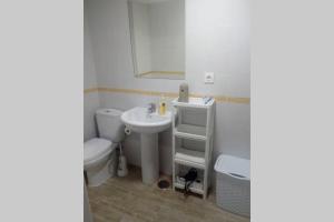 een badkamer met een witte wastafel en een toilet bij Apartamento Soleado in Tarifa +1 foto