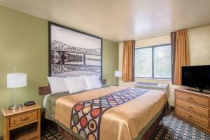 een hotelkamer met een bed en een televisie bij Super 8 by Wyndham Wheeling Saint Clairsville OH Area in Wheeling