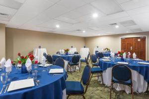 a room with tables and chairs with blue tables at Hawthorn Suites by Wyndham Naples in Naples