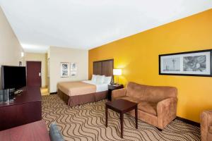 una habitación de hotel con una cama y un sofá en La Quinta by Wyndham Floresville, en Floresville
