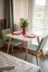 a table with two chairs and a vase with flowers at MyRiviéra Apartman in Balatonfüred