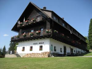 ein Gebäude mit einem Balkon und Blumen darauf in der Unterkunft Hotel Garni Haus am Wald in Reifnitz