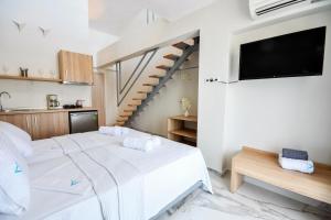 a bedroom with a white bed and a staircase at Alos Utopia in Stavros