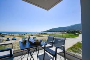 d'une table et de chaises sur un balcon avec vue sur la plage. dans l'établissement Alos Utopia, à Stavros