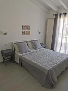 Un dormitorio con una cama grande y una ventana en Affittacamere Alisso, en Olbia