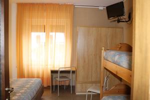 a bedroom with a bunk bed and a desk and a window at Hotel Milano in Folgaria