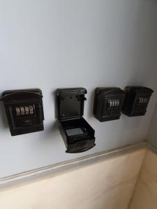 Inn Faro - Casa Amarela - Guest House في فارو: جدار عليه أربعة صناديق كهربائية سوداء