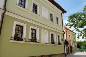 a yellow building with windows and balconies on a street at Гостерія"Old Town" in Kamianets-Podilskyi