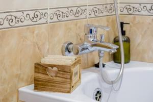 a bathroom sink with a faucet and a wooden box at Гостерія"Old Town" in Kamianets-Podilskyi +61 photos
