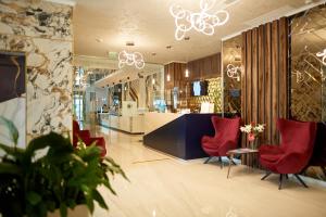 a lobby with red chairs and a counter in a store at Stavros Hotel in Mamaia