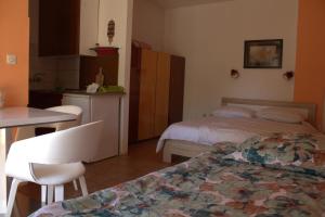 a room with two beds and a table and a kitchen at Apartments Marija in Murine