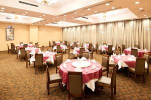 un comedor con mesas y sillas con manteles rosados en Marroad Inn Hanno, en Hanno