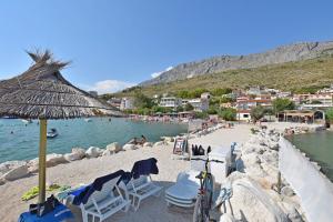 a beach with chairs and a bike on the sand at Apartments Kate in Duće