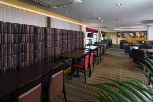 a row of tables and chairs in a restaurant at Holiday Inn Express London Luton Airport, an IHG Hotel in Luton