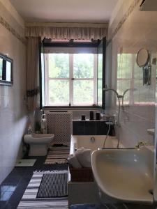 baño con bañera, lavabo y ventana en CASA Lux, en Serravalle Pistoiese