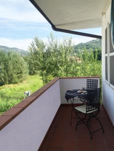 a table and chair on a balcony with a view at CASA Lux in Serravalle Pistoiese