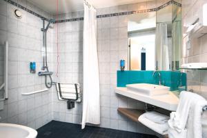 
a bathroom with a sink, toilet and shower at Holiday Inn Express London Luton Airport, an IHG Hotel in Luton
