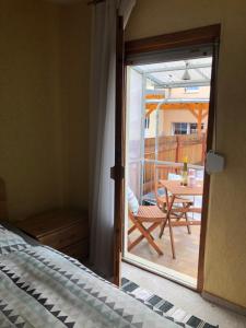 a bedroom with a door open to a patio with a table at Ferienhaus in Sankt Aldegund