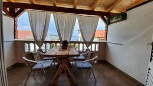a table and chairs in a room with windows at Apartments Balen in Rab +32 photos