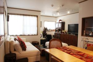 een woonkamer met een bank en een tv bij HAMA HILLS Shinjuku in Tokyo
