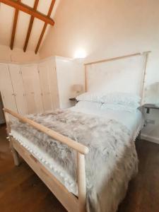 a bedroom with a bed with a white comforter at 7 Grove Farm Barns in Sculthorpe