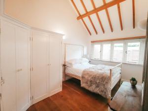 a bedroom with a bed and a window at 7 Grove Farm Barns in Sculthorpe