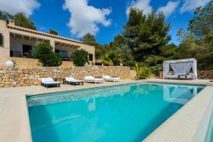 una piscina frente a una villa en Casa Olivo, en Sant Josep de sa Talaia