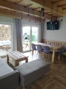 uma sala de estar com uma mesa e cadeiras e um sofá em Domček Michaela em Zuberec