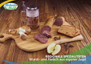 una tabla de cortar de madera con carne y pan y una bebida en Jagd-Angler-Suite-03-im-Wald-am-See, en Kyritz