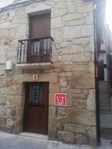 Edificio de piedra con puerta y balcón en Apartamentos SEOANE, en Finisterre
