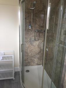 a bathroom with a shower with a glass door at The Globe Inn in Penrith