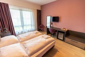 una camera d'albergo con due letti e una televisione di A22 Hotel Gyál a Gyál