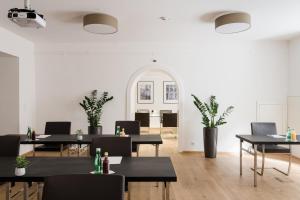 a dining room with tables and chairs and plants at Hotel Mariahilf in Graz