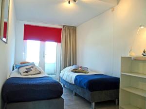 アウウドルプにあるVakantieappartement de Kabbelaarの小さなベッドルーム(ベッド2台、窓付)