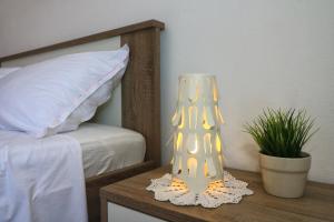 lampa siedząca na stole obok łóżka w obiekcie Apartmani Mikin w mieście Betina